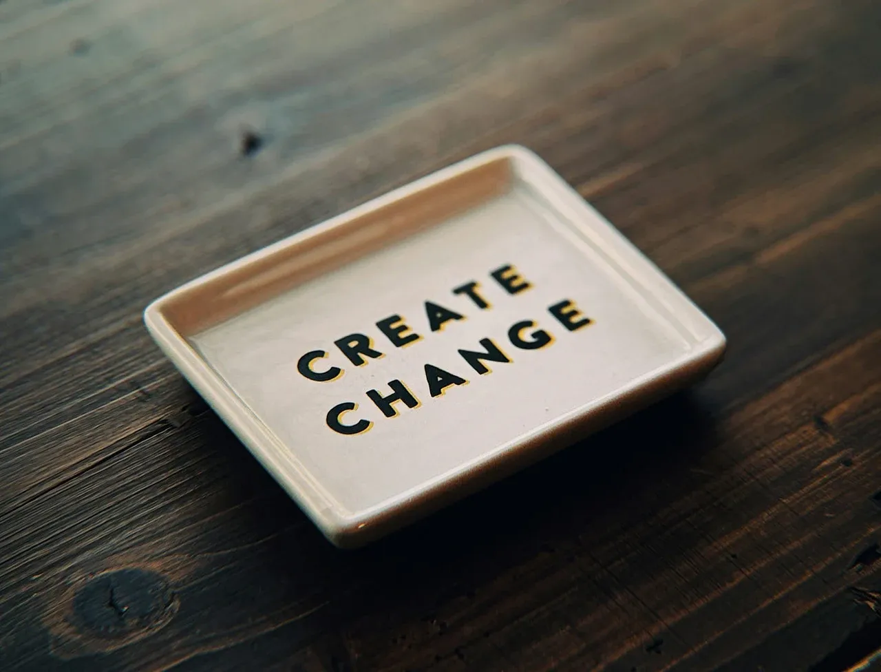 Ceramic tray on a wooden table with the words: create change