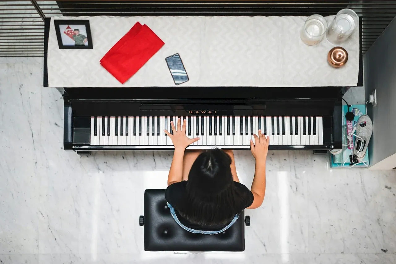 Top view of a person playing an upright piano